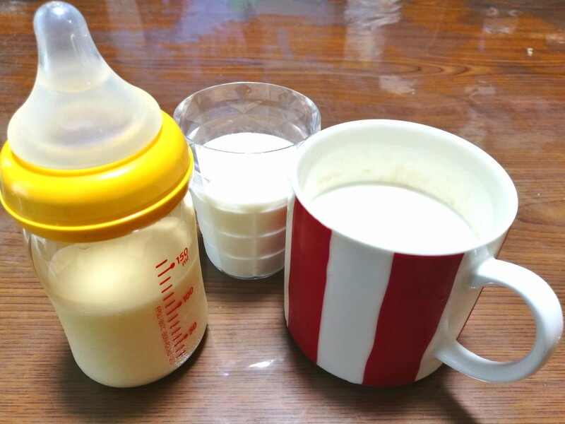 哺乳瓶とコップとカップに入った牛乳